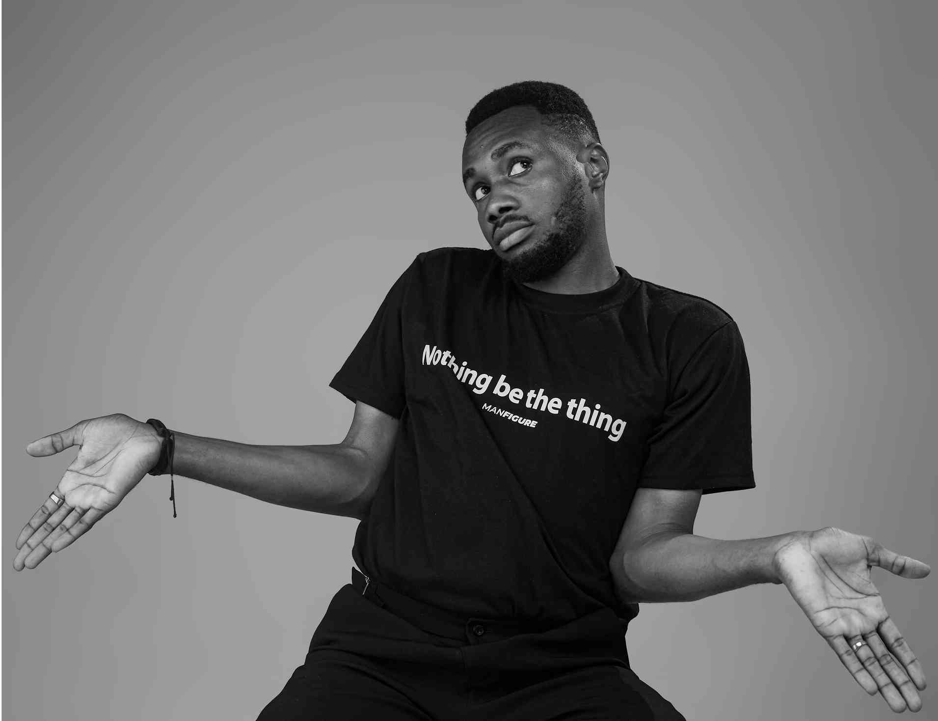 Black and white image of a man shrugging with a clueless expression. 